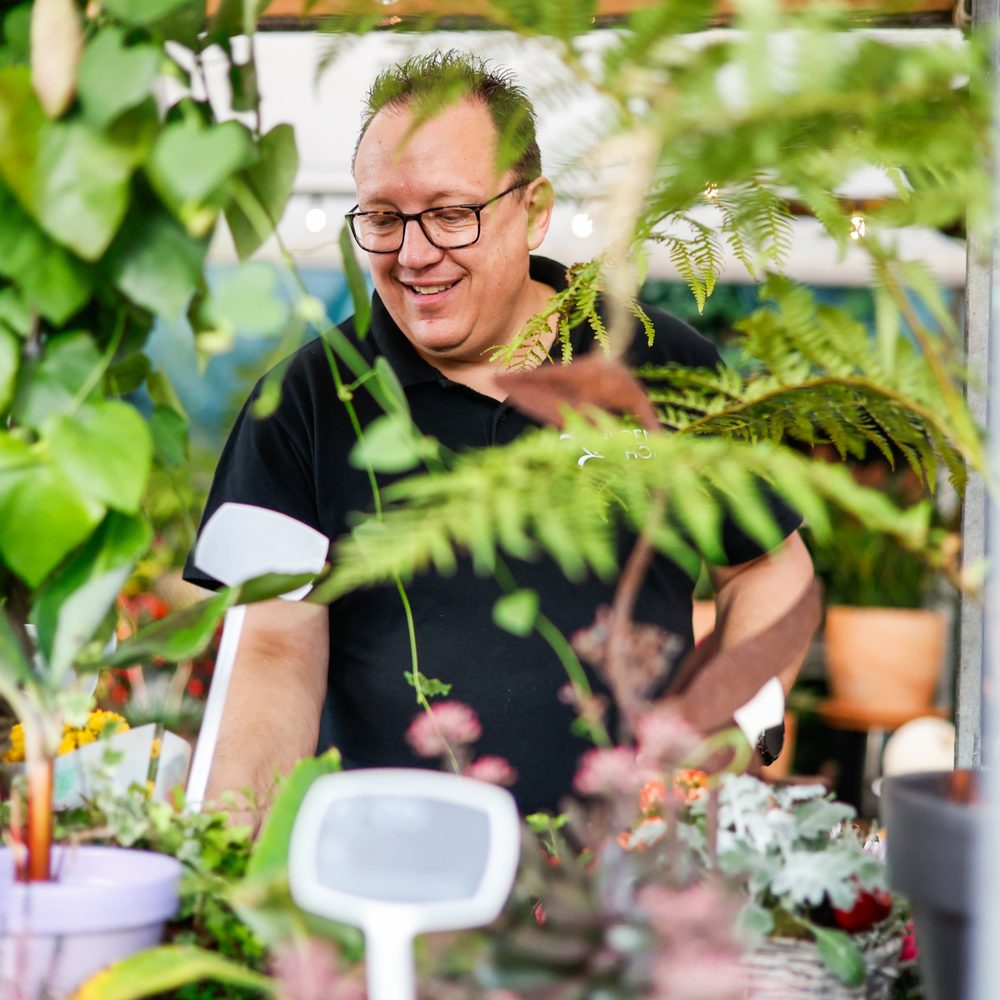 De eigenaar lacht tussen de planten